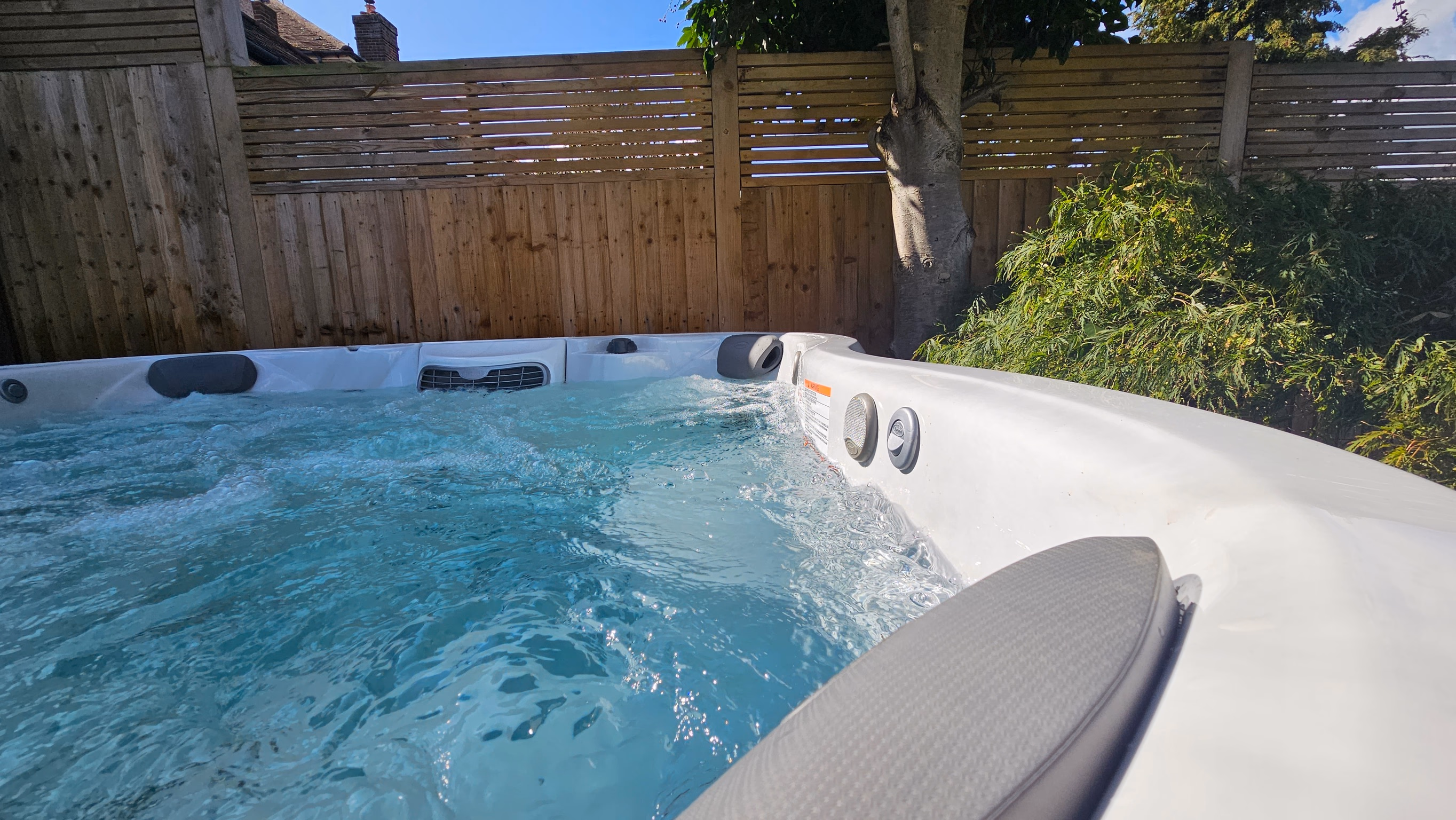 Freshly cleaned J5 Spa Services hot tub running in a sunny garden